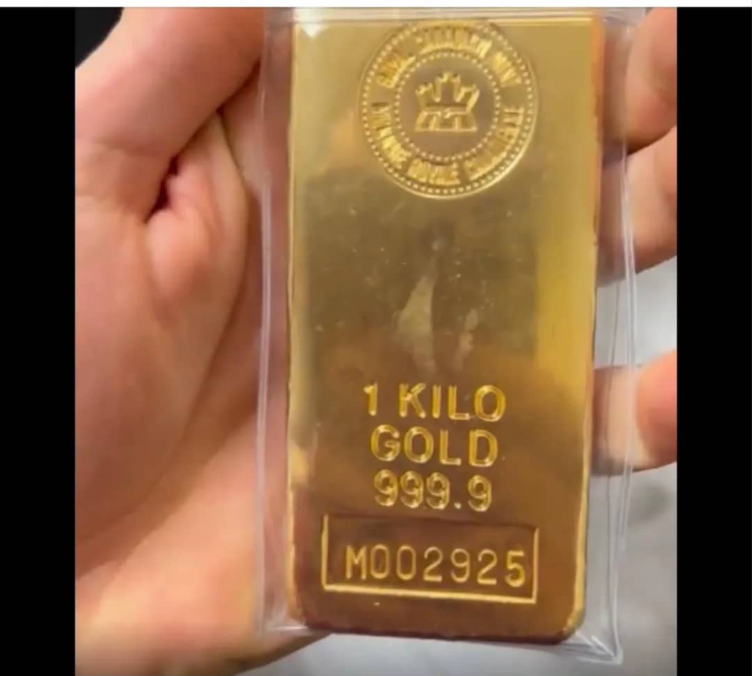 Sealed one kilo gold bar held in hand